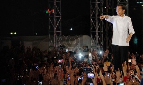 Presiden Jokowi menyapa para pendukungnya pada Konser Salam 3 Jari di lapangan Monumen Nasional, Jakarta, Senin (20/10) malam.   (Republika/Yasin Habibi)