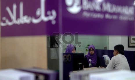 Ekonomi Syariah Solusi Krisis Global: Karyawan melayani nasabah berada di kantor Bank Muamalat, Jakarta, Kamis (9/4).