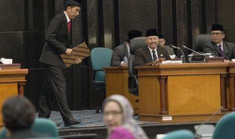 Gubernur DKI Jakarta yang juga Presiden terpilih, Joko Widodo (kiri) berjalan di dekat Ketua DPRD DKI Jakarta Ferrial Sofyan (tengah) dan Wakil Ketua Boy Sadikin (kanan) menuju podium untuk memberikan pendapat akhir pada Rapat Paripurna DPRD DKI Jakarta di