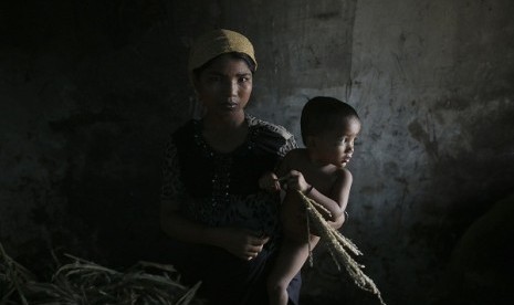 Hla Hla May, a Rohingya Muslim woman displaced by violence, holds her one year old daughter Roshan at a former rubber factory that now serves as their shelter, near Sittwe April 29, 2013. 