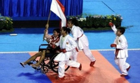 Karateka putri Indonesia, Fitrianingsih Nur Hadiyanti (du kanan), Yulanda Asmuruf (tengah), dan Martinel Prihastuti (kanan) mengarak rekannya Tantri Widyasari yang cedera saat bertanding seusai pertandingan babak final Kumite Beregu Putri SEA Games XXVI me