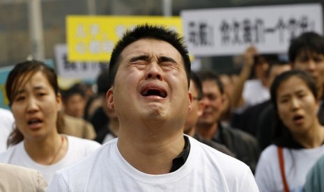  Keluarga korban penumpang pesawat Malaysia Airlines MH370  menangis saat berunjuk rasa di depan gedung Kedubes Malaysia di Beijing, Selasa (25/3).   (Reuters/Kim Kyung-Hoon)