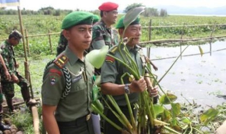 KSAD Jenderal TNI Moeldoko didampingi Wadanjen Kopassus Brigjen Jaswandi tengah memperlihatkan enceng gondok yang ia cabut di Danau Tondano, Kabupaten Minahasa, Sulawesi Utara, Jumat (28/6).