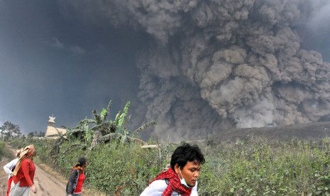 Sejumlah warga berlarian menyelamatkan diri saat erupsi Gunung Sinabung di Kabupaten Karo, Sumatera Utara, Sabtu (1/2).  (AP Photo)