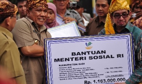 Mensos Salim Segaf Al Jufri menyerahkan bantuan sosial saat Deklarasi Kearaifan Lokal di Tatanga, Palu, Selasa (20/8). 