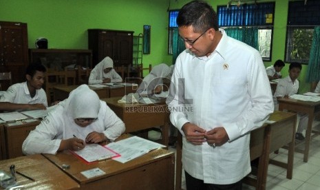 Menteri Agama Lukman Hakim Saifuddin (kiri) usai memantau proses pelaksanaan ujian nasional (UN) di madrasah aliyah negeri (MAN) 2 Jakarta, Senin (13/4). (Republika/Rakhmawaty La'lang)