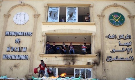 Para pengunjuk rasa menyerang dan merusak markas Ikhwanul Muslimin di distrik Muqatam di Kairo, Senin (1/7).       (AP/Khalil Hamra)