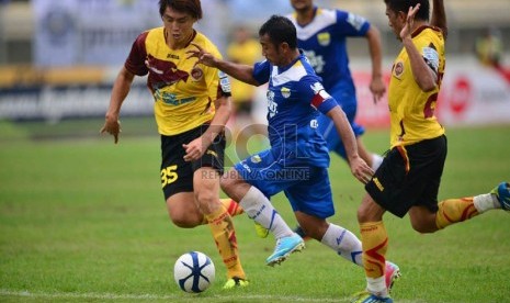  Pemain Persib Bandung Firman Utina dikepung pemain Sriwijaya FC, Herman Dzumafo  dalam pertandingan Liga Super Indonesia 2013 di Stadion Si Jalak Harupat, Bandung, Sabtu (15/6).  (Republika/Yogi Ardhi) 