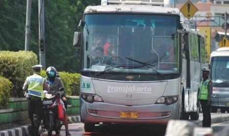 Petugas menindak pengendara motor yang melintas di jalur Transjakarta di kawasan Terminal Kampung Melayu, Jakarta Timur, Senin (22/9).(Republika/Rakhmawaty La'lang)