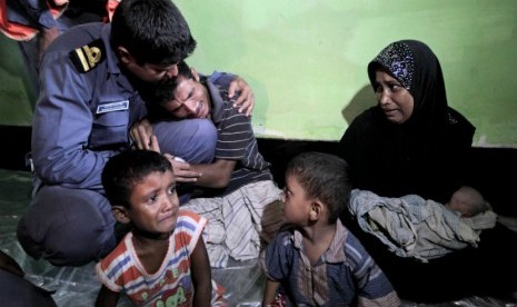  Pria muslim Rohingya asal Myanmar, Mohammad Rafique (tengah) menangis ketika bersama keluarganya  akan dipulangkan ke Myanmar dekat pos penjaga perbatasan di Taknaf,Bangladesh,Jumat (22/6).  (Saurabh Das/AP)   