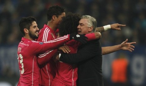 Real Madrid's Isco, Raphael Varane and Marcelo celebrate with coach Carlo Ancelotti (L-R) after scoring a goal against Schalke 04 during their Champions League Round of 16 first leg soccer match in Gelsenkirchen, February 18, 2015
