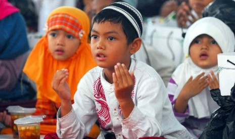 Sejumlah anak yatim piatu khusuk berdoa saat mengikuti acara 