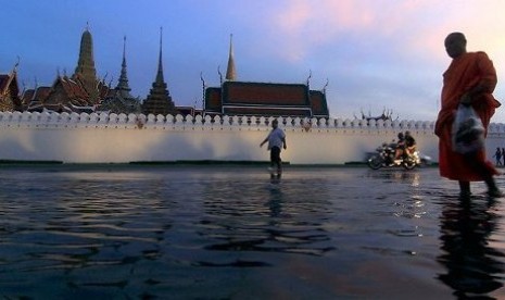 Seorang biksu melintasi kawasan terendam banjir di Thailand