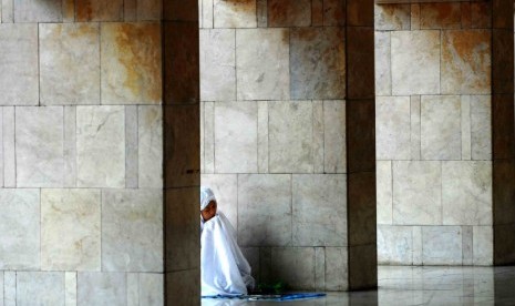 Seorang perempuan tengah khusyuk berdoa usai melaksanakan ibadah Shalat Dzuhur di Masjid Istiqlal, Jakarta, Senin (23/7). (Agung Supriyanto/Republika)