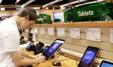 Seorang warga AS sedang mencoba tablet di sebuah toko gadget di New York 