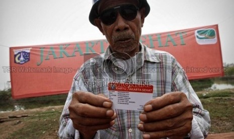   Seorang warga Marunda, Jakarta Utara menunjukkan kartu Jakarta Sehat, yang diberikan Gubernur DKI Jakarta, Joko Widodo. Senin (12/11). (Adhi Wicaksono)