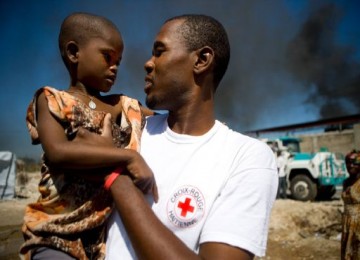 Seorang relawan yang menggendong bocah Haiti
