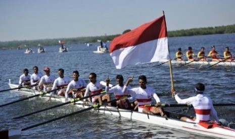 Tim rowing Indonesia mengibarkan bendera merah putih seusai memenangi partai final nomor ringan M8+ Sea Games ke-27 di Ngalaik Dam, Naypyitaw, Myanmar, Selasa (17/2).