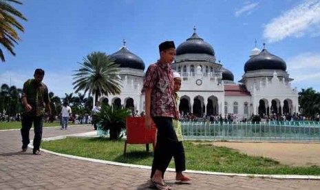 Warga berjalan usai menunaikan shalat Jumat di Masjid Raya Baiturrahman, Banda Aceh.
