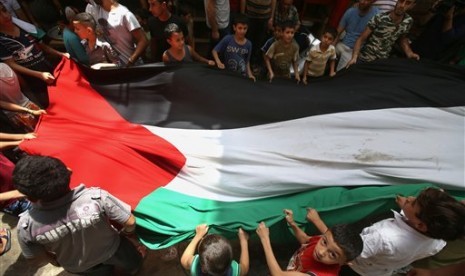 Warga Gaza membentangi bendera Palestina.