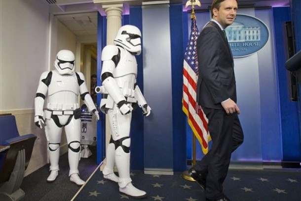 Sekretaris Pers Gedung Putih berjalan bersama Stormtroopers dalam pemutaran Star Wars: The Force Awakens di Gedung Putih.