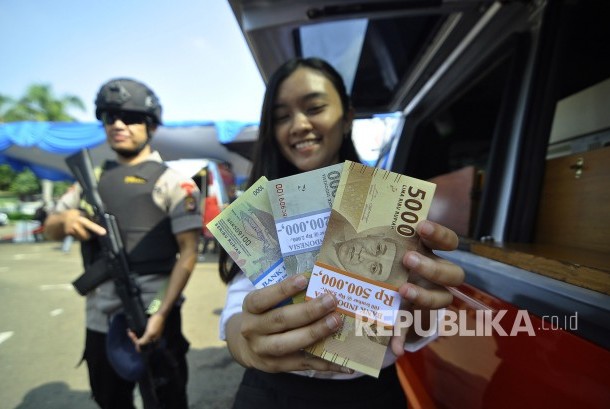 Penjual jasa penukaran uang baru menawarkan uang baru kepada pengguna jalan di pinggiran jalan, Surabaya, Jawa Timur, Selasa (6/6). Pada bulan Ramadan, para penjual jasa penukaran uang baru ramai bermunculan di pinggir-pinggir jalan, mereka menukarkan uang baru tersebut dengan tambahan 10 persen dari jumlah uang yang ditukarkan.