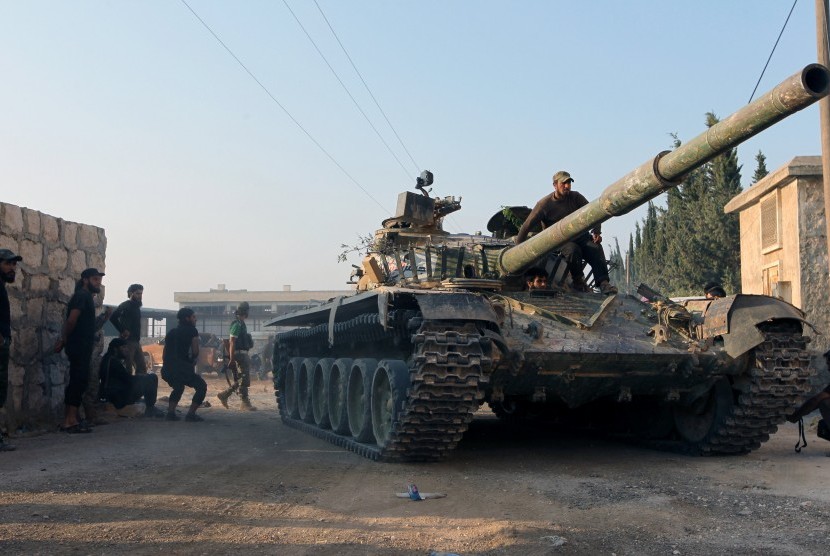 Gerilyawan menaiki kendaraan tank di kawasan Aleppo, Suriah.