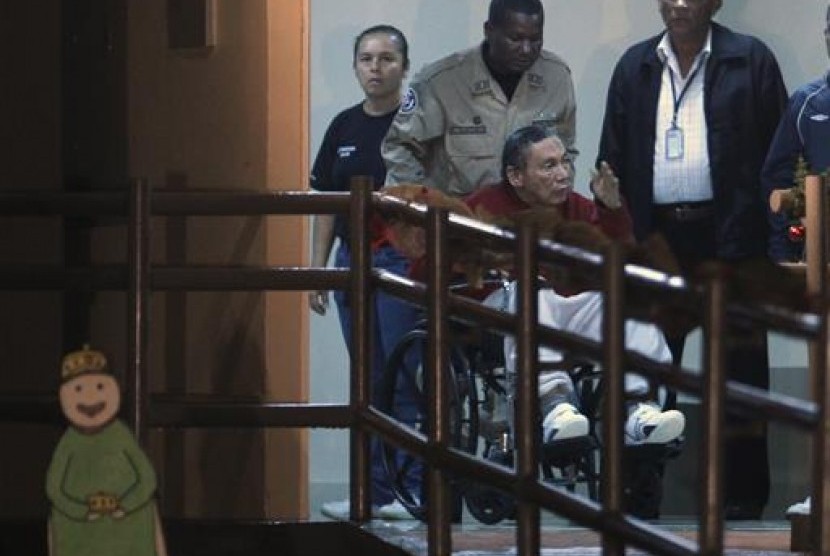 Mantan jenderal Panama Manuel Noriega didorong oleh polisi di atas kursi rodanya di penjara El Renacer di pinggiran Panama City, Panama pada 11 Desember 2011.