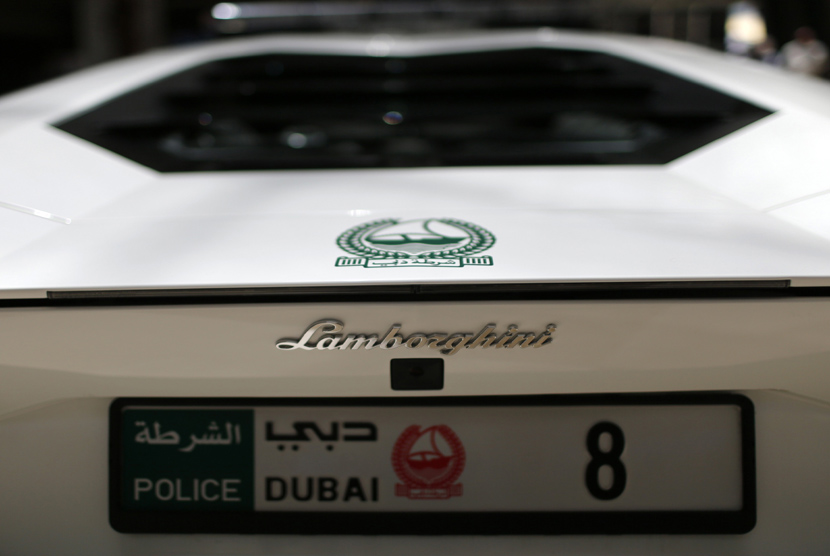 Seorang polisi wanita berdiri di dekat mobil Mercedes yang digunakan oleh kepolisian Dubai.     (Reuters/Ahmed Jadallah)