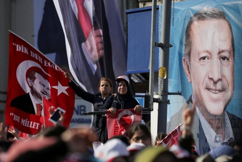 Pendukung Presiden Turki Recep Tayyip Erdogan melambaikan bendera nasional dan bendera 