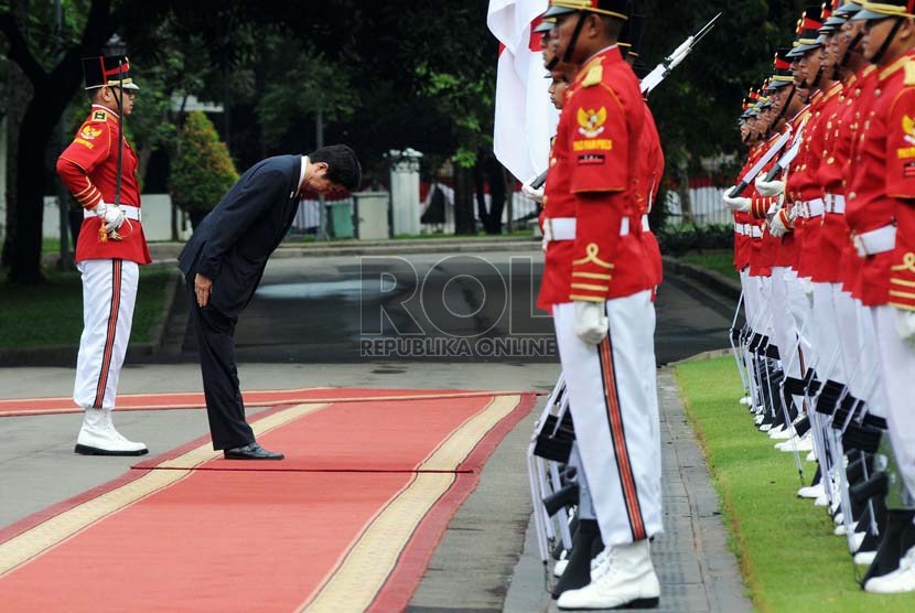   Perdana Menteri Jepang Shinzo Abe memberikan penghormatan saat upacara penyambutan kenegaraan di Istana Negara, Jakarta, Jumat (18/1).  (Republika/Aditya Pradana Putra)
