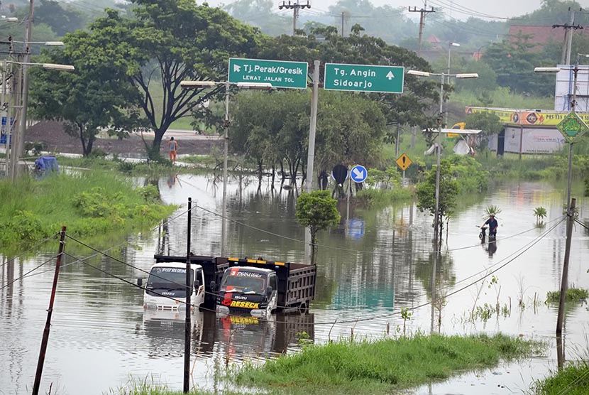 Sejumlah kendaraan terjebak banjir di jalan raya Porong, Sidoarjo, Jawa Timur, Jumat (12/2).  (Antara/Kuwadi)