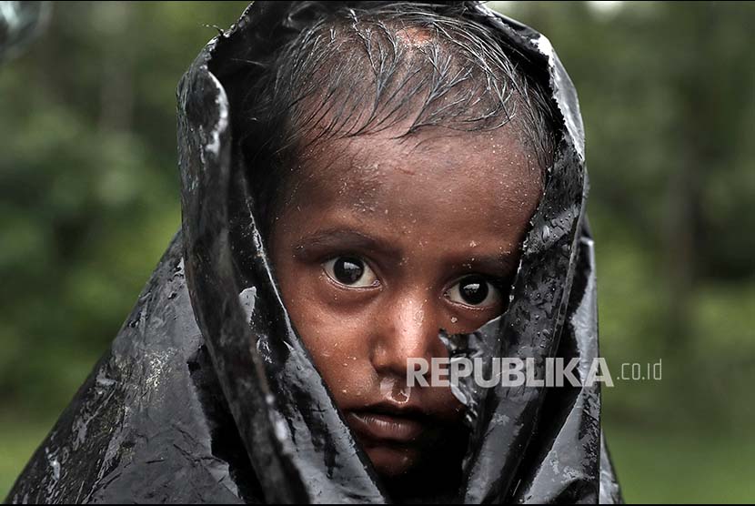 Seorang anak Rohingya menunggu bantuan internasional di kamp pengungsi Cox Bazaar, Bangladesh.