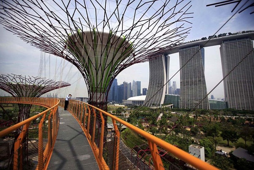 Seorang pengunjung tengah memotret pemandangan taman Vertikal yang memiliki pohon dengan ketinggian antara 25 sampai dengan 50 meter dekat lokasi pusat bisnis di Singapura, Senin (30/4).  (Wong Maye-E/AP)