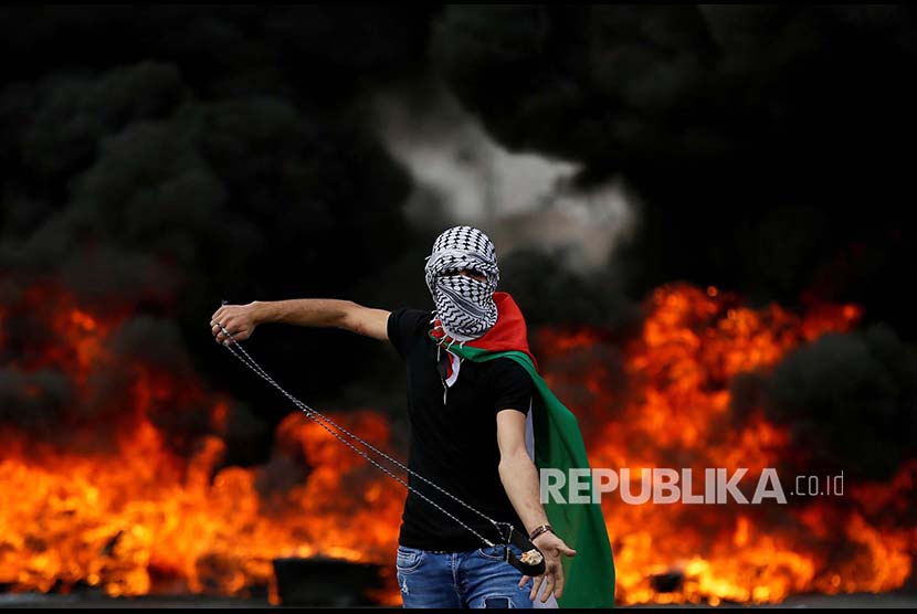 Seorang warga Palestina membawa ketapel pada peringatan 70 tahun hari Nakba (hari di mana warga Palestina diusir secara besar-besaran oleh Israel) di Ramallah, Tepi Barat Palestina, Selasa (15/5)