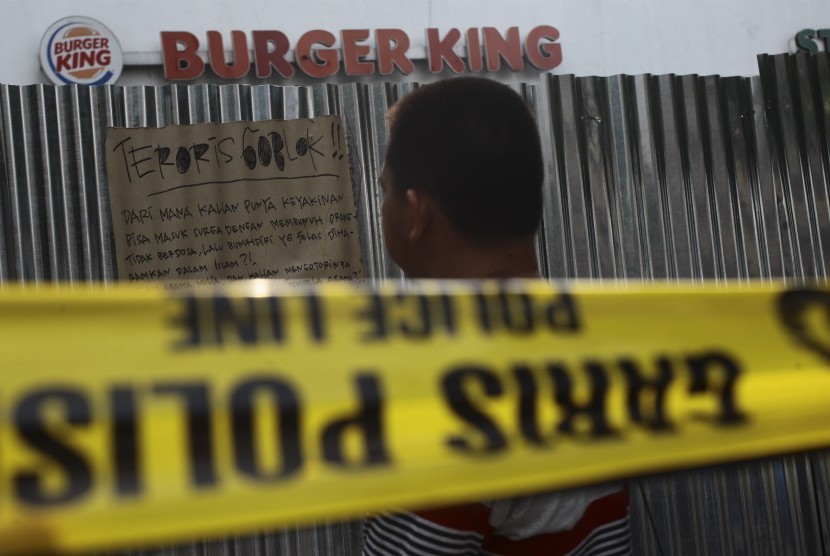 Warga melintas di depan restoran Burger King pascapenyerangan teroris di pos polisi dan sejumlah gedung di Sarinah Thamrin Jakarta, Jumat (15/1). 