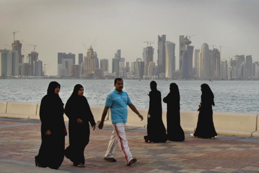 Warga Qatar menikmati berjalan-jalan di pinggir laut di Doha.