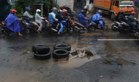  Tumpukan ban bekas disimpan di sebuah lubang akibat genangan air hujan di jalan PLN, Duren Tiga, Jakarta Selatan, Kamis (23/1).    (Republika/Agung Supriyanto)