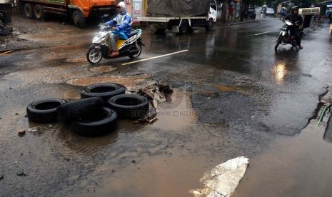  Tumpukan ban bekas disimpan di sebuah lubang akibat genangan air hujan di jalan PLN, Duren Tiga, Jakarta Selatan, Kamis (23/1).    (Republika/Agung Supriyanto)