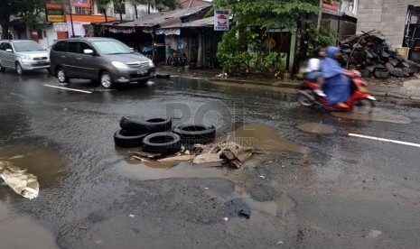  Tumpukan ban bekas disimpan di sebuah lubang akibat genangan air hujan di jalan PLN, Duren Tiga, Jakarta Selatan, Kamis (23/1).    (Republika/Agung Supriyanto)