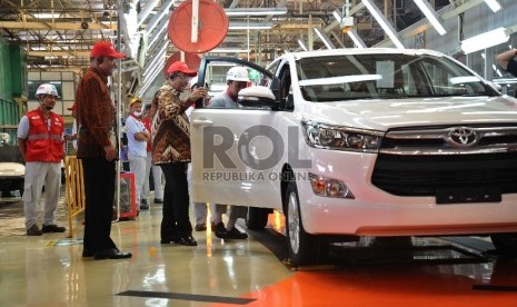 (dari kiri) Wakil Presiden Toyota Motor manufacturing Indonesia (TMMIN) Warih Andang Tjahyono, Menteri Perindustrian Saleh Husin melihat pengecekan kualitas mobil usai line off Toyota Innova di pabrik PT TMMIN, Karawang, Jawa Barat, Selasa (24/11). 