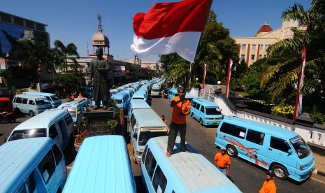 [ilustrasi] Seorang sopir angkutan umum mengibarkan bendera Merah Putih saat aksi unjuk rasa menolak transportasi berbasis daring atau 