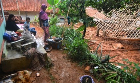 Warga menyaksikan rumah yang tertimbun material tanah longsor (ilustrasi).  Fenomena banjir dan tanah longsor yang melanda wilayah Kabupaten Majalengka, Jawa Barat menyebabkan tiga akses jalan tertutup. Kejadian banjir ini terjadi setelah hujan deras pada Rabu (8/12) pukul 19.00 WIB. Struktur tanah yang labil juga menjadi pemicu terjadinya longsordibeberapa titik.