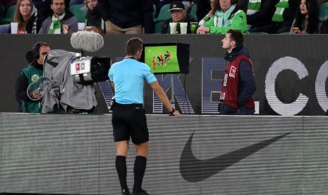 [ilustrasi] Wasit mengecek video assistant referee (VAR) dalam sebuah laga. IFAB meminta VAR tidak digunakan secara berlebihan dalam pertandingan sepak bola.