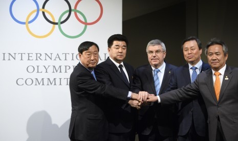 (Kiri ke kanan) Presiden Panitia Penyelenggara PyeongChang 2018 (POCOG) Lee Hee-beom, Menteri Olahraga dan Presiden Komite Olimpiade Korea Utara Kim Il-guk, Presiden Komite Olimpiade Internasional (IOC) Thomas Bach pada pertemuan di Lausanne, Swis, 20 Januari 2018. Pertemuan ini menyepakati 22 atlet Korea Utara akan bertisipasi pada Olimpiade. 