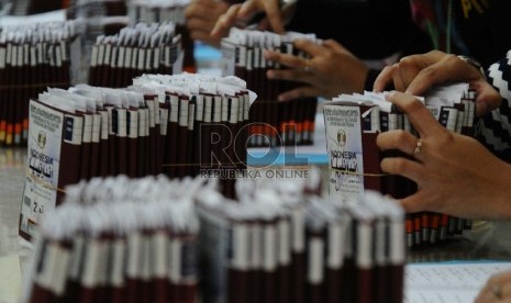 Petugas Penyelenggara Ibadah Haji (PPIH) sedang mendata paspor calon jamaah Haji di asrama haji, Bekasi, Jawa Barat, Ahad (23/8).  (Republika/Tahta Aidilla)