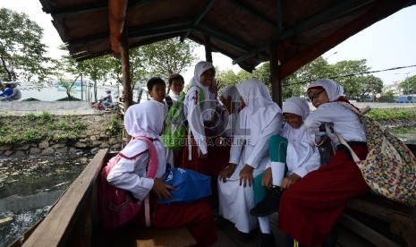 Sejumlah anak menumpang eretan untuk menyeberangi sungai Ciliwung di Kawasan Kemayoran, Jakarta Pusat, Jumat (8/5). (Republika/Raisan Al Farisi)