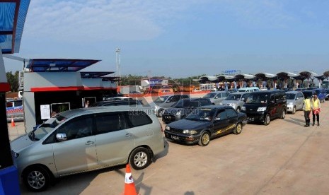 Sejumlah pengendara mobil membayar tol di loket tambahan saat memasuki jalan tol Cikopo, Purwakarta, Jawa Barat, Sabtu (11/7).  (Republika/Agung Supriyanto)