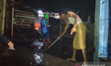 Warga membersihkan tumpukan lumpur yang terbawa air bah. Banjir setinggi pinggang orang dewasa melanda Kampung Baru, Kelurahan Sayang, Kabupaten Cianjur, Ahad (27/10).