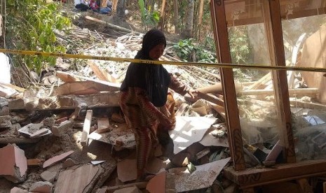  Korban hujan batu Dede Lia (26) tak kuasa menahan sedih melihat kondisi rumahnya yang hancur tertimpa batu berukuran besar